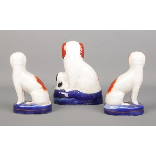 13 - A pair of 19th century Staffordshire dogs along with another example with puppy. Height 15cm.