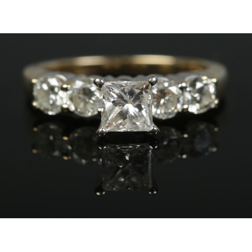 141 - A 14ct yellow gold diamond ring. Set with a central square cut diamond flanked either side by two br... 