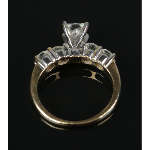 141 - A 14ct yellow gold diamond ring. Set with a central square cut diamond flanked either side by two br... 