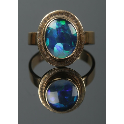 145 - A 9ct gold opal doublet ring. Size O. 4.04g.