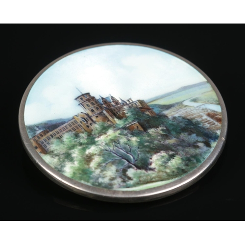 146 - A continental silver and enamel brooch decorated with a landscape scene and castle. Stamped 800 to b... 