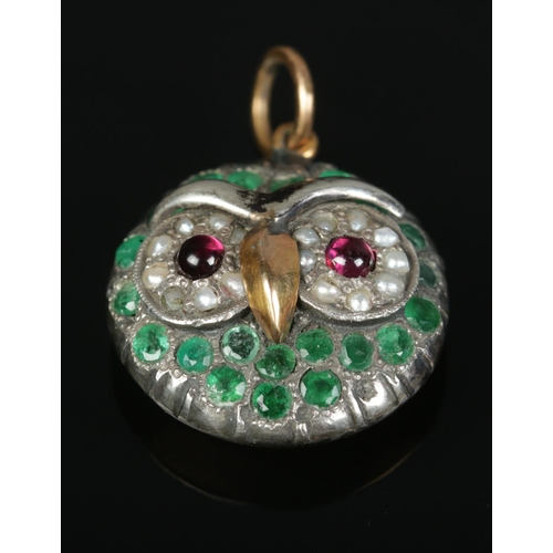 148 - A high carat yellow gold and white metal pendant formed as an owl. With garnet, seed pearl and emera... 