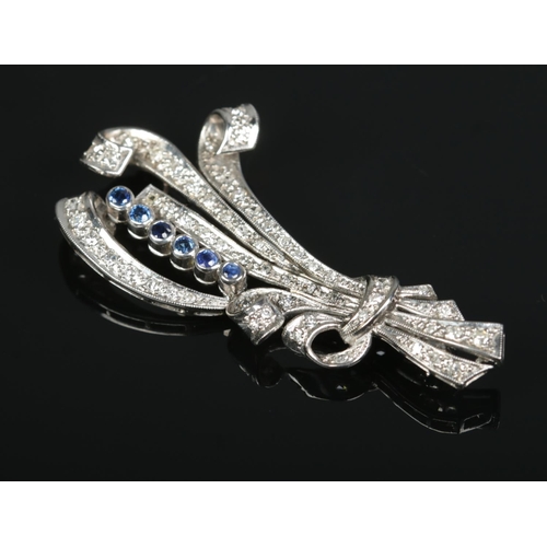 171 - An Art Deco platinum, diamond and sapphire scroll brooch. Length 6cm. 9.64g.