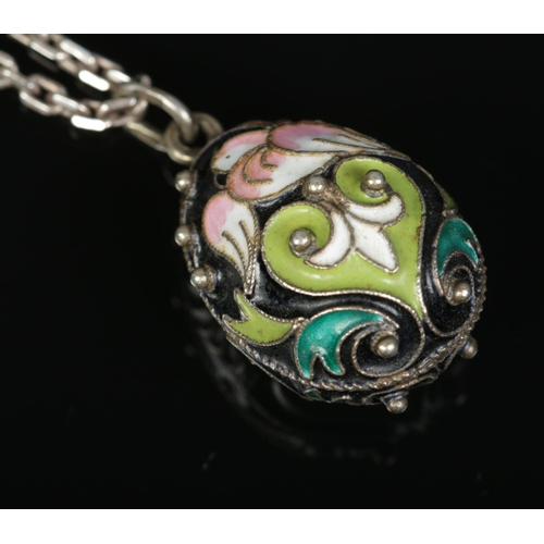 179 - A Russian silver and enamel egg pendant decorated with doves. The pendant stamped 925 with star and ... 