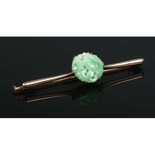 185 - A 9ct gold carved jadeite bar brooch. Maker's mark HGB. Length 6cm.