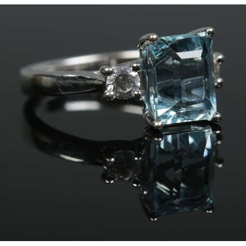 193 - An 18ct white gold aquamarine and diamond three stone ring. Having large square cut aquamarine flank... 