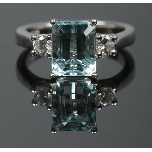 193 - An 18ct white gold aquamarine and diamond three stone ring. Having large square cut aquamarine flank... 