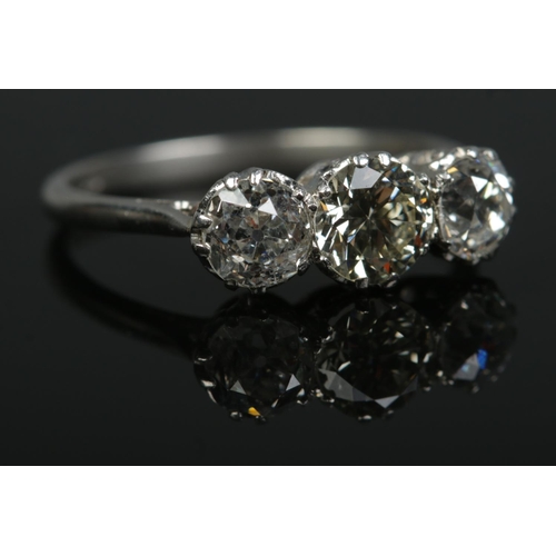 196 - A platinum and old cut diamond three stone ring. Total diamond approximately 1.6ct. Size N. 3.36g.