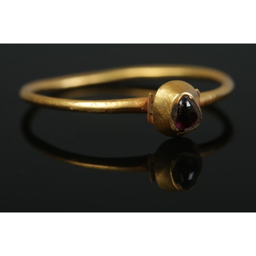 202 - A medieval gold ring in pie crust setting with cabochon garnet. Possibly 13th/14th century. Size P. ... 