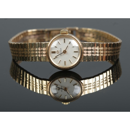 205 - A ladies 9ct gold Omega manual wristwatch on 9ct gold Omega strap. With box and papers. 18.9g.