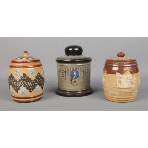 22 - Three Doulton tobacco jars. Includes Doulton Lambeth stoneware and Royal Doulton harvest and Titania... 