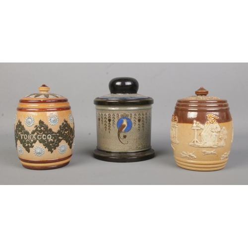 22 - Three Doulton tobacco jars. Includes Doulton Lambeth stoneware and Royal Doulton harvest and Titania... 