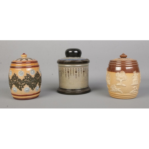 22 - Three Doulton tobacco jars. Includes Doulton Lambeth stoneware and Royal Doulton harvest and Titania... 