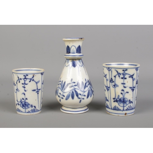 23 - A small Dresden blue and white vase, along with two similar beakers. Vase 12cm.