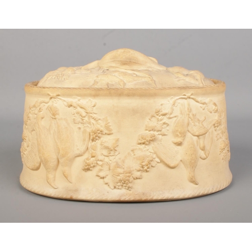 24 - A Wedgwood Cane Ware game tureen. Relief decorated. With liner. Width 22cm.