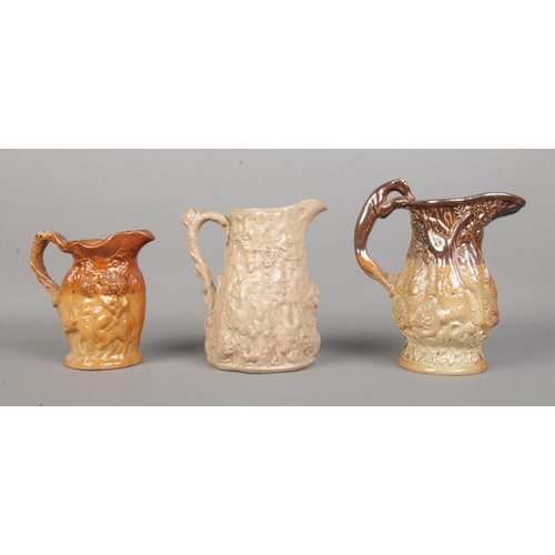 34 - Three 19th century relief moulded stoneware jugs. Includes Silenus and Hanging Game examples. Talles... 