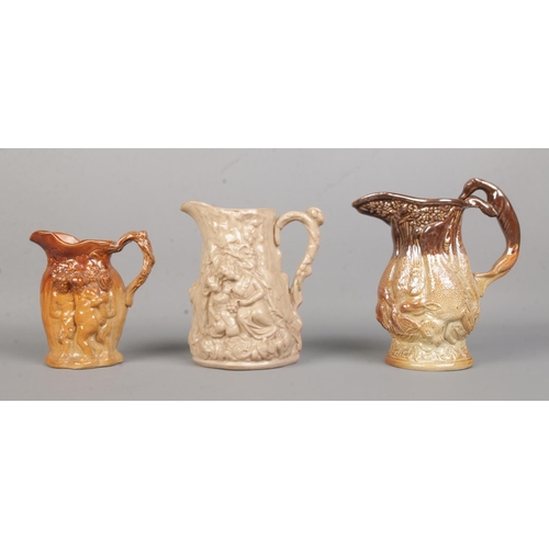 34 - Three 19th century relief moulded stoneware jugs. Includes Silenus and Hanging Game examples. Talles... 