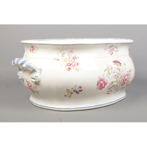 36 - A Victorian ceramic footbath decorated with flowers. Height 21cm, Width 53cm.