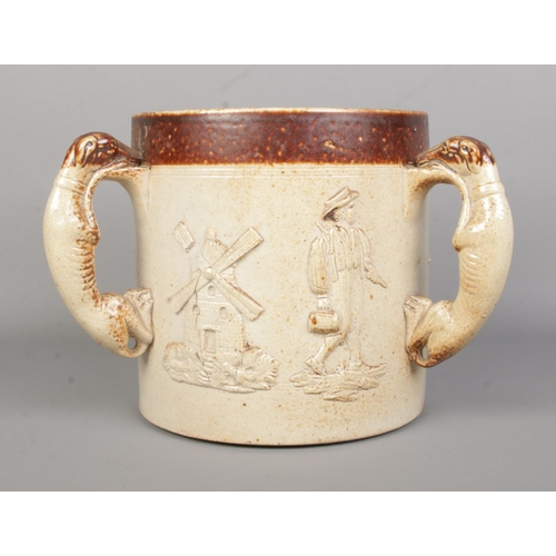 37 - A large 19th century stoneware tyg. With moulded dog handles and relief hunting/farming scenes. Heig... 