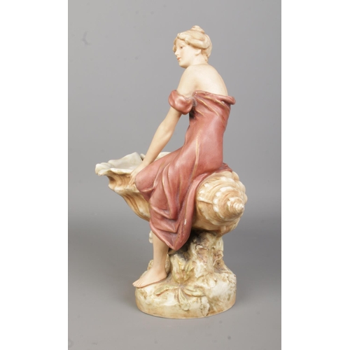 42 - A Royal Dux figure of a maiden seated on a large shell. Height 32cm.