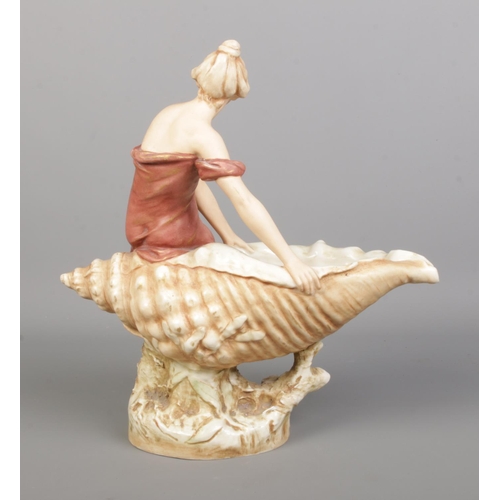 42 - A Royal Dux figure of a maiden seated on a large shell. Height 32cm.