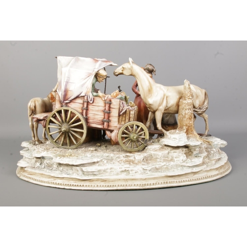 44 - An Antonio Borsato Italian porcelain figure group, depicting figures gathered around a horse and wag... 