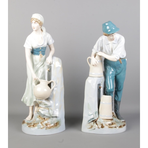 45 - A pair of Royal Dux figures modelled as male and female collecting water. Height 48cm.