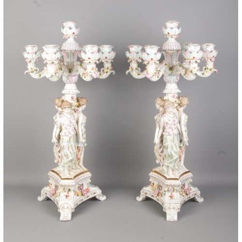 53 - A pair of Meissen style porcelain figural candelabra. Both having three maidens and applied floral d... 