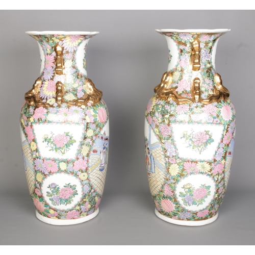 55 - A large pair of Chinese Canton famille rose vases. With panels depicting figures and floral borders.... 