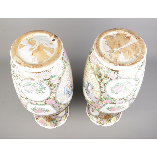 55 - A large pair of Chinese Canton famille rose vases. With panels depicting figures and floral borders.... 