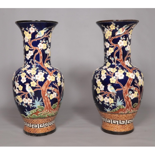 57 - A large pair of Chinese floor vases, blue ground and decorated with birds and prunus blossom. Height... 