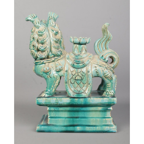 65 - A turquoise glazed temple lion joss stick holder raised on plinth. Height 32cm.