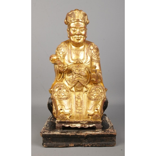 66 - An antique Chinese carved and painted wooden figure of a seated Emperor/Official. Height 41cm.