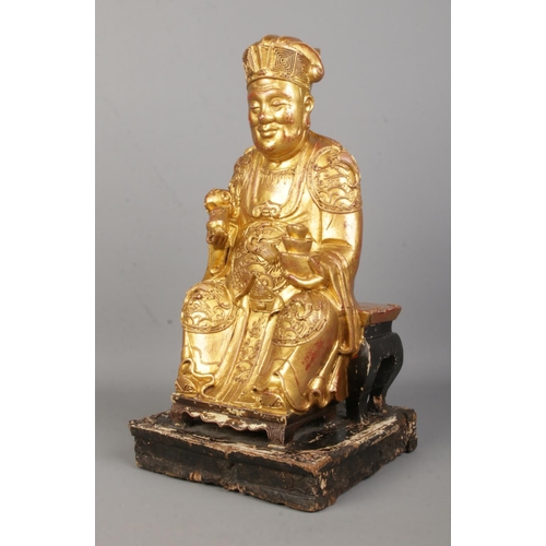 66 - An antique Chinese carved and painted wooden figure of a seated Emperor/Official. Height 41cm.