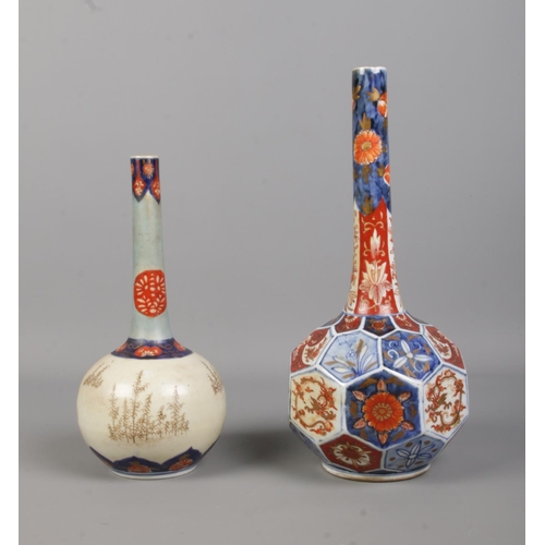 67 - Two Japanese imari bottle vases. One with panelled base. Height of tallest 31cm.