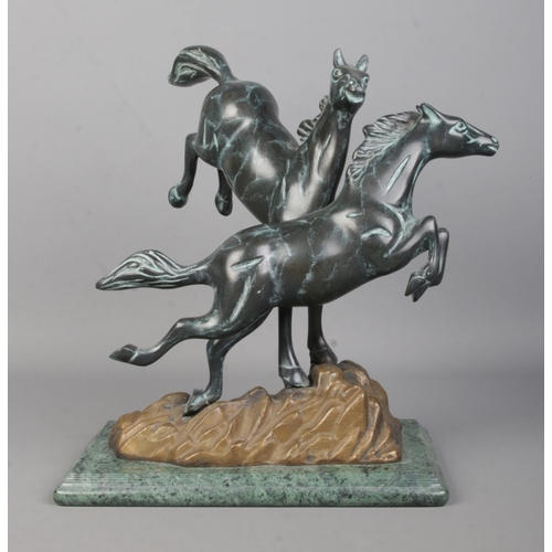 73 - A Verdi Gris bronze sculpture modelled as two frolicking horses raised on marble base. Height 30.5cm... 