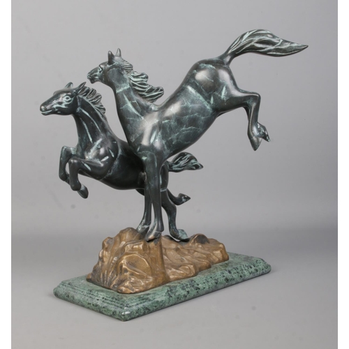 73 - A Verdi Gris bronze sculpture modelled as two frolicking horses raised on marble base. Height 30.5cm... 