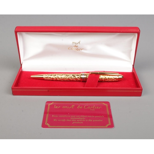 85 - Le Must De Cartier, a gold plated ball point pen with box and authenticity card.