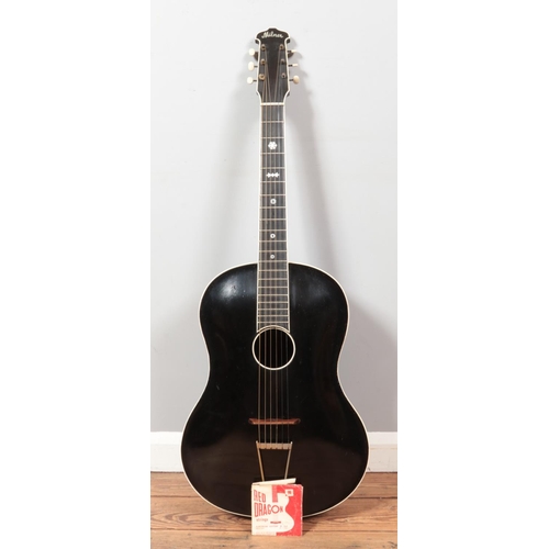 99 - A vintage Milner acoustic guitar. Having black body, white trim and mother of pearl inlay to fret bo... 