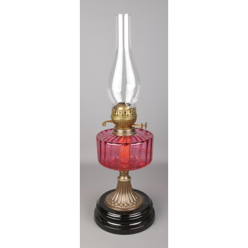 536 - A Flash of Slough flamingo glass and brass oil lamp, on stepped circular base.