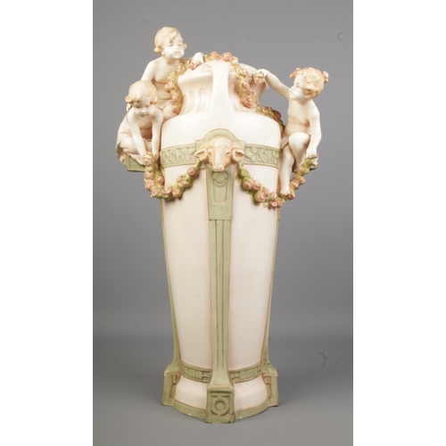 538 - A substantial Royal Dux style vase adorned with cherubs/putti and rams head decoration 

Hx54cm