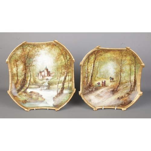 545 - Two hand painted and gilt ceramic wall plaques in the style of Limoges depicting woodland scenes inc... 