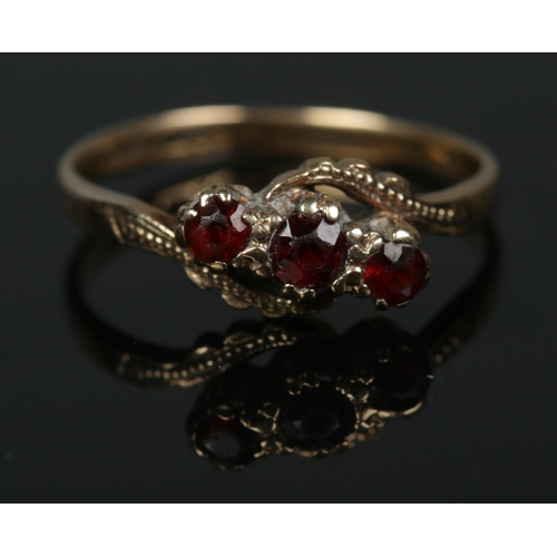 582 - A 9ct gold three stone garnet twist ring 

1.91g
Size O