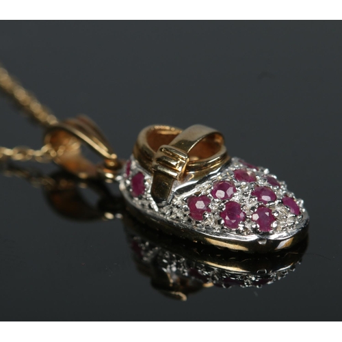 596 - A 9ct gold ruby set shoe pendant on chain.

2.95g