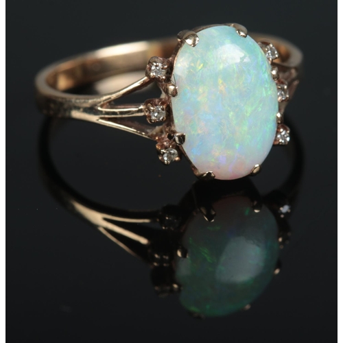 629 - A 9ct gold ring set with large opal stone surrounded by 6 small diamonds 

2.66g
R1/2