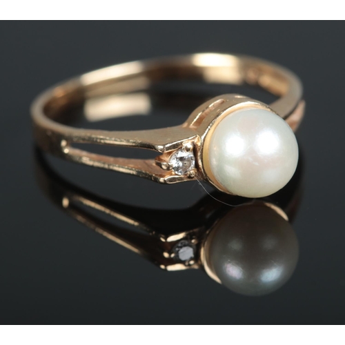 634 - A 14ct gold ring set with pearl and small diamond 

2.45g
Q1/2