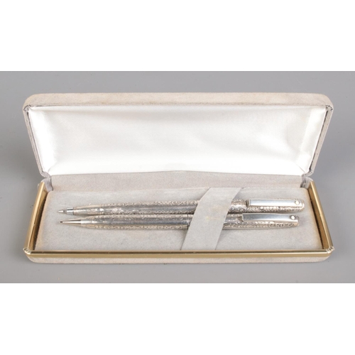 671 - A cased Sheaffer sterling silver propelling pencil and ball point pen set featuring floral engraving... 