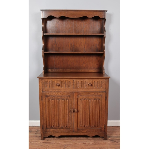 673 - A mid-twentieth century oak dresser, with cupboard base. Height: 178cm, Width: 95cm, Depth: 44cm.