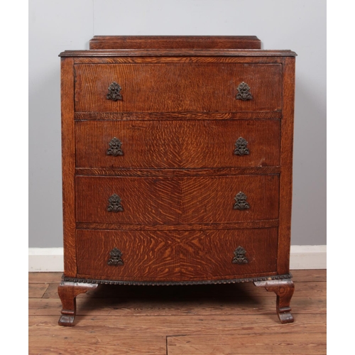 678 - An oak and ply bow fronted chest of four drawers, featuring cherub drop pull handles and waved beadi... 