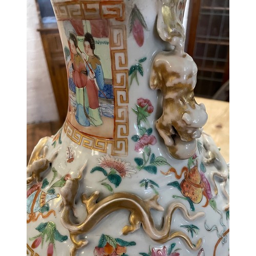 56 - A large late 19th/ early 20th century Chinese Canton Famille Rose vase. With gilt lion dog handles a... 